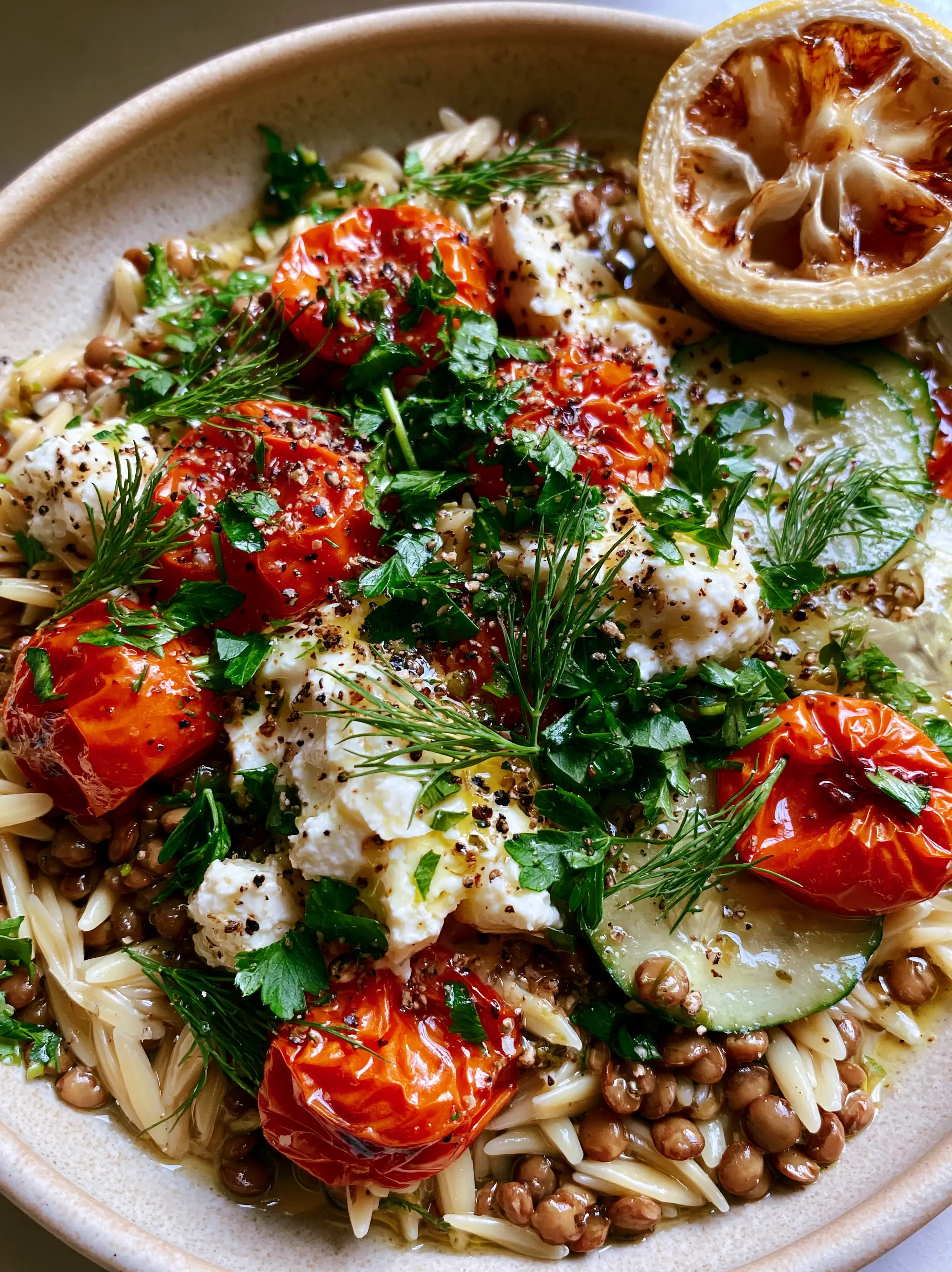 Close up of al dente orzo and brown lentils tossed in a lemon-herb vinaigrette with feta. (mediterranean lentil and orzo)